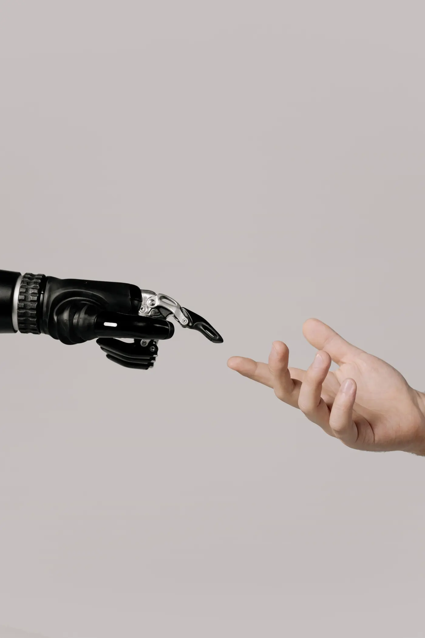 A human hand and a bionic hand reaching towards each other